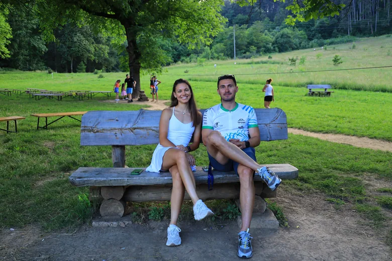 A couple resting on a bench by the meadow